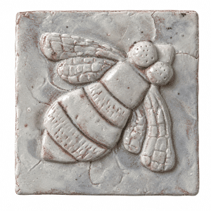 Pale glazed ceramic tile with a raised bee design