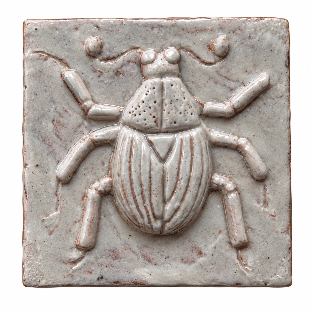 Pale glazed ceramic tile with a raised scarab beetle design