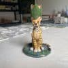 Spotted cheetah ceramic candlestick with a green leaf candle cup