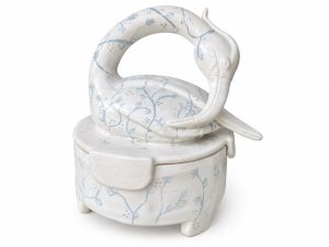 White glazed ceramic heron jar with a curved bird-shaped lid and pale blue botanical decoration