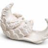 White glazed ceramic pangolin reclining on its back, with raised scales and a curved tail